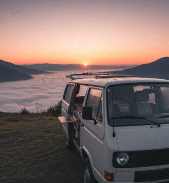 Furgoneta camper aparcada de frente, con la puerta trasera abierta, mirando hacia un espectacular amanecer sobre un mar de nubes en un valle gallego.